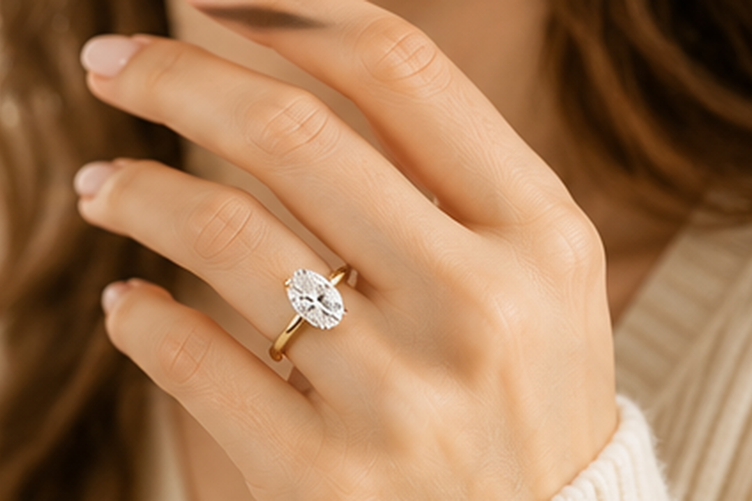 Close-up of a hand wearing an oval lab-grown diamond engagement ring.